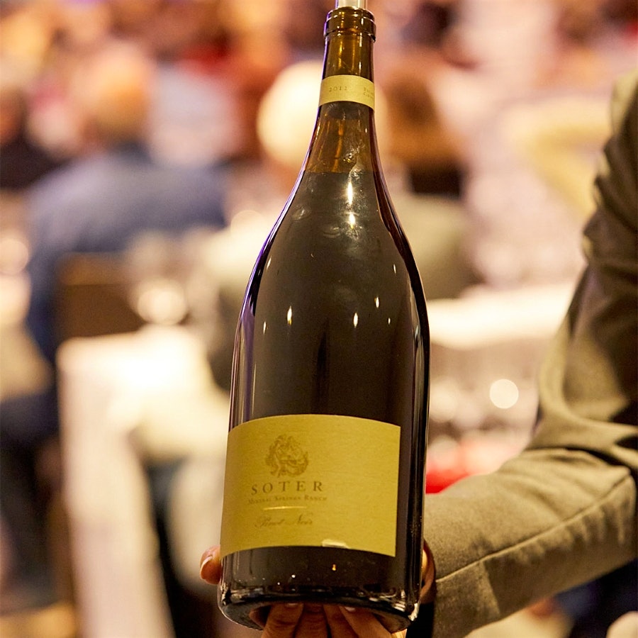 A person holding a magnum bottle of Soter Pinot Noir Yamhill-Carlton District Mineral Springs Ranch 2012 at the 2023 New York Wine Experience